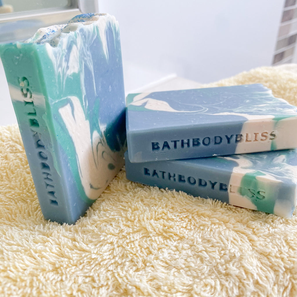 Three bars of Bathbody Bliss soap on a textured surface