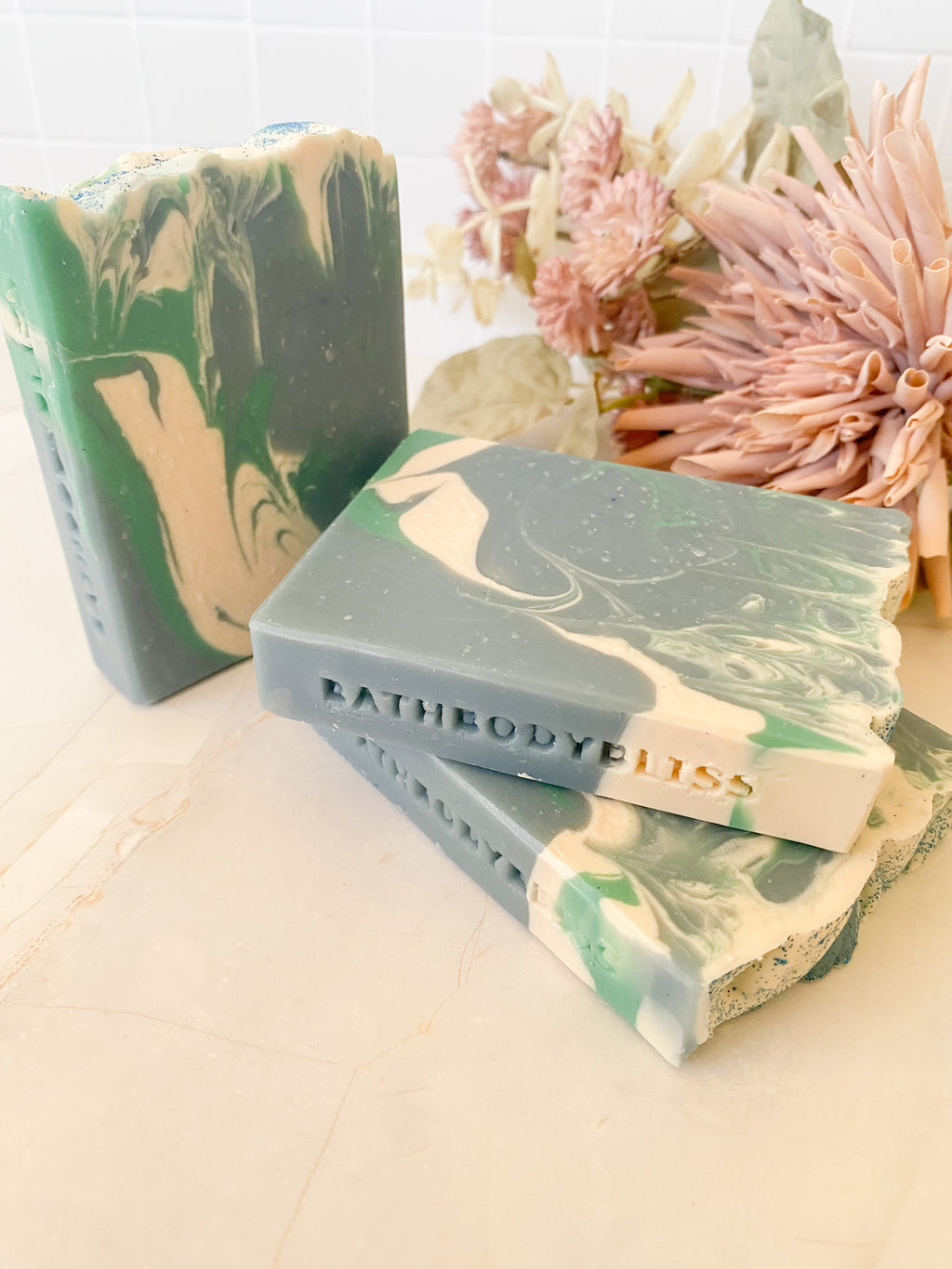 Marble-patterned soap bars with 'Bathbody Bliss' branding on a light background.