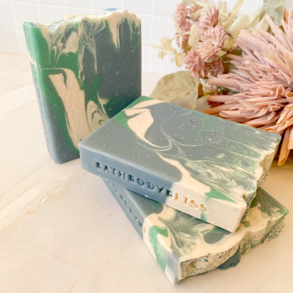 Marbled green and beige soap bars with 'Bathbodybliss' branding on a light background.