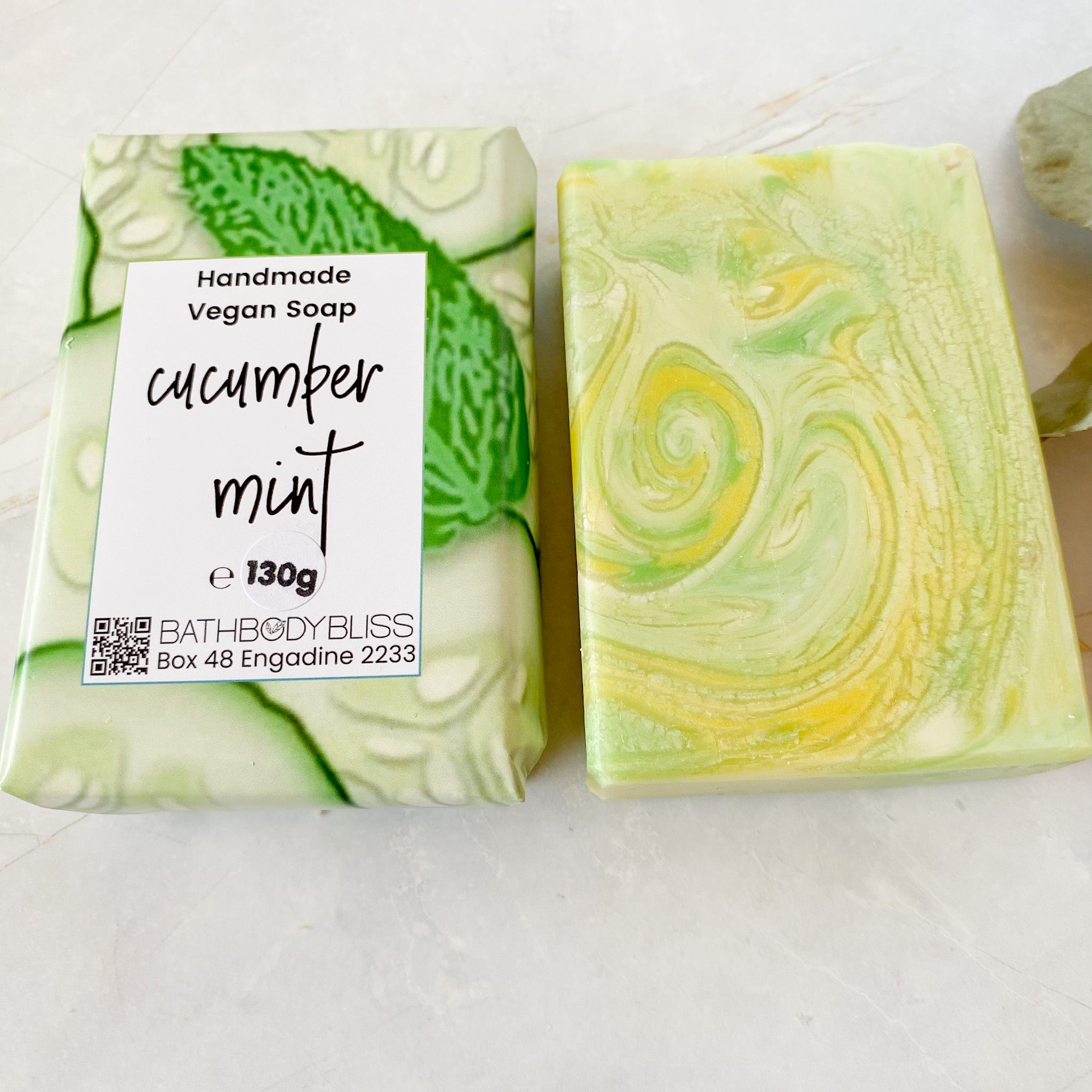wrapped and unwrapped bars of cucumber mint soap on a light background
