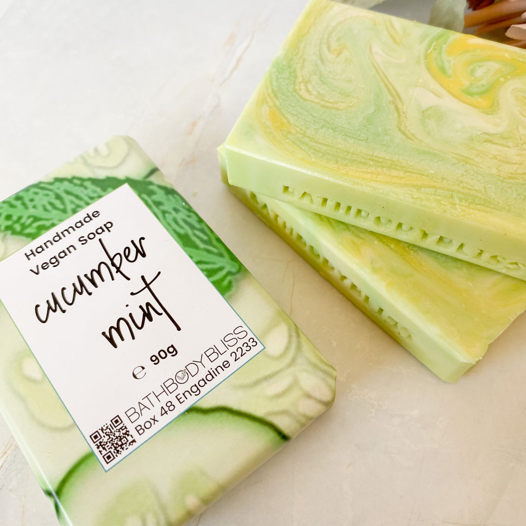 swirled green, yellow & white cucumber mint soap bars on a light surface