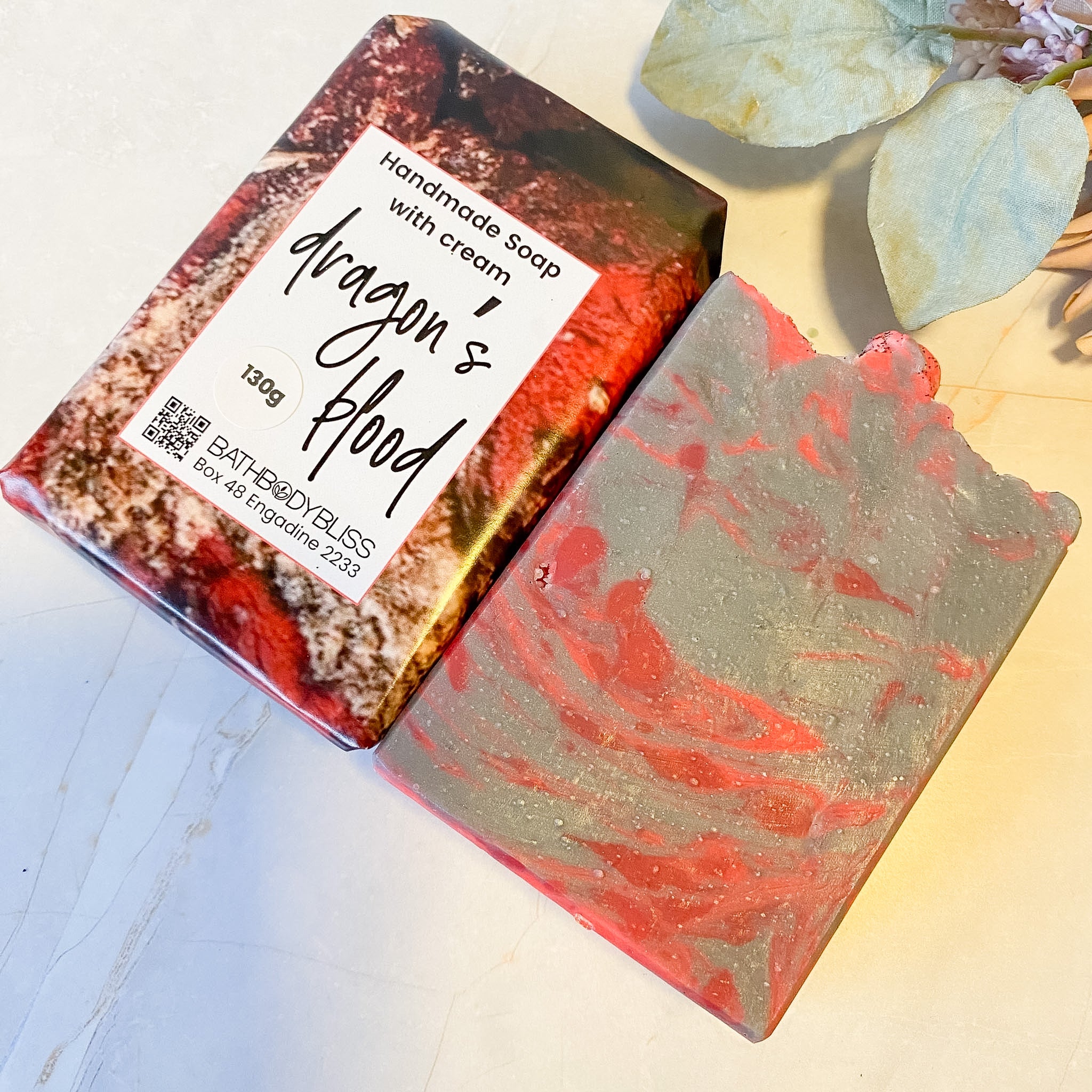 Handmade soap with 'Dragon's Blood' design on packaging and soap bar.