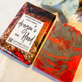 Handmade soap bar with 'Dragon's Blood' packaging on a textured surface.