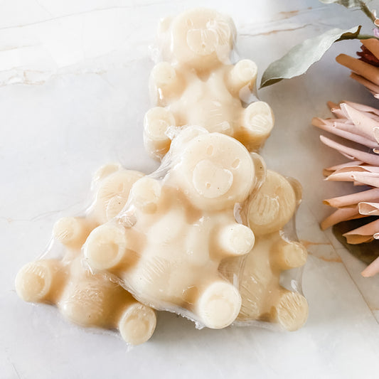 pile of creamy coloured teddy bear shaped soap bars on a white background