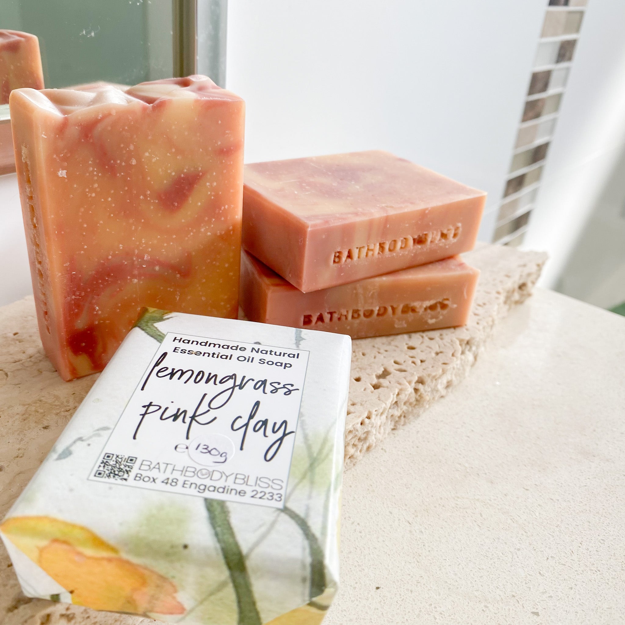 Handmade soap bars with a packaging label on a textured surface