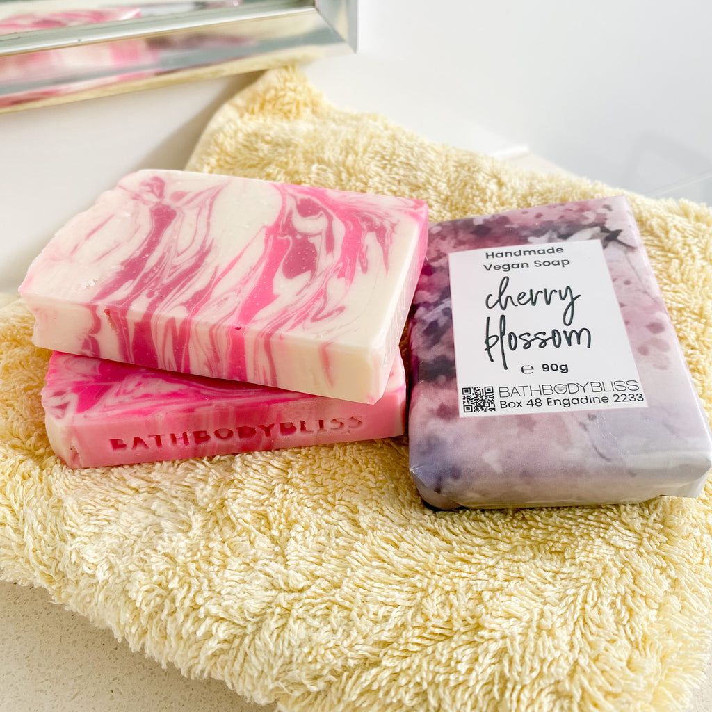 pink and white soap bars stacked on a yellow towel
