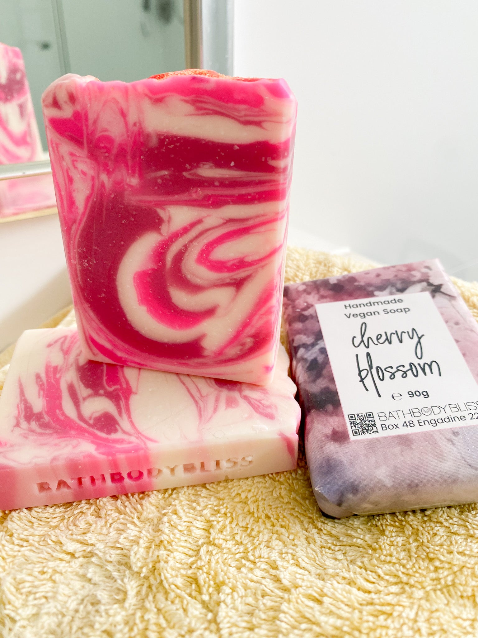 pik and white swirled soap bars on a yellow towel