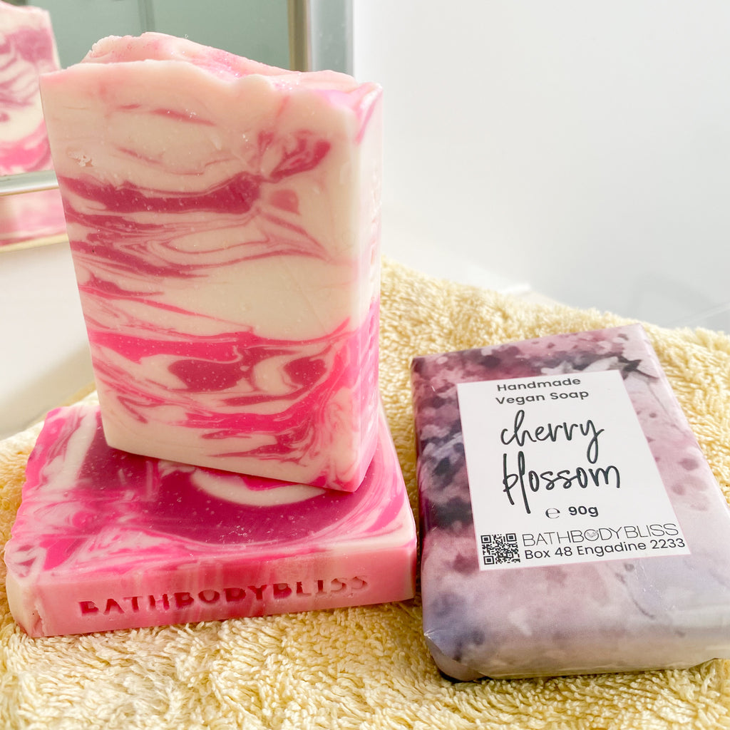 two unwrapped and 1 wrapped soap bars on a yellow towel