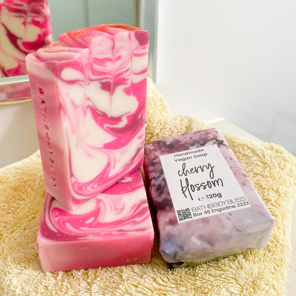 pink and white swirled cherry blossom soap bars on a yellow towel