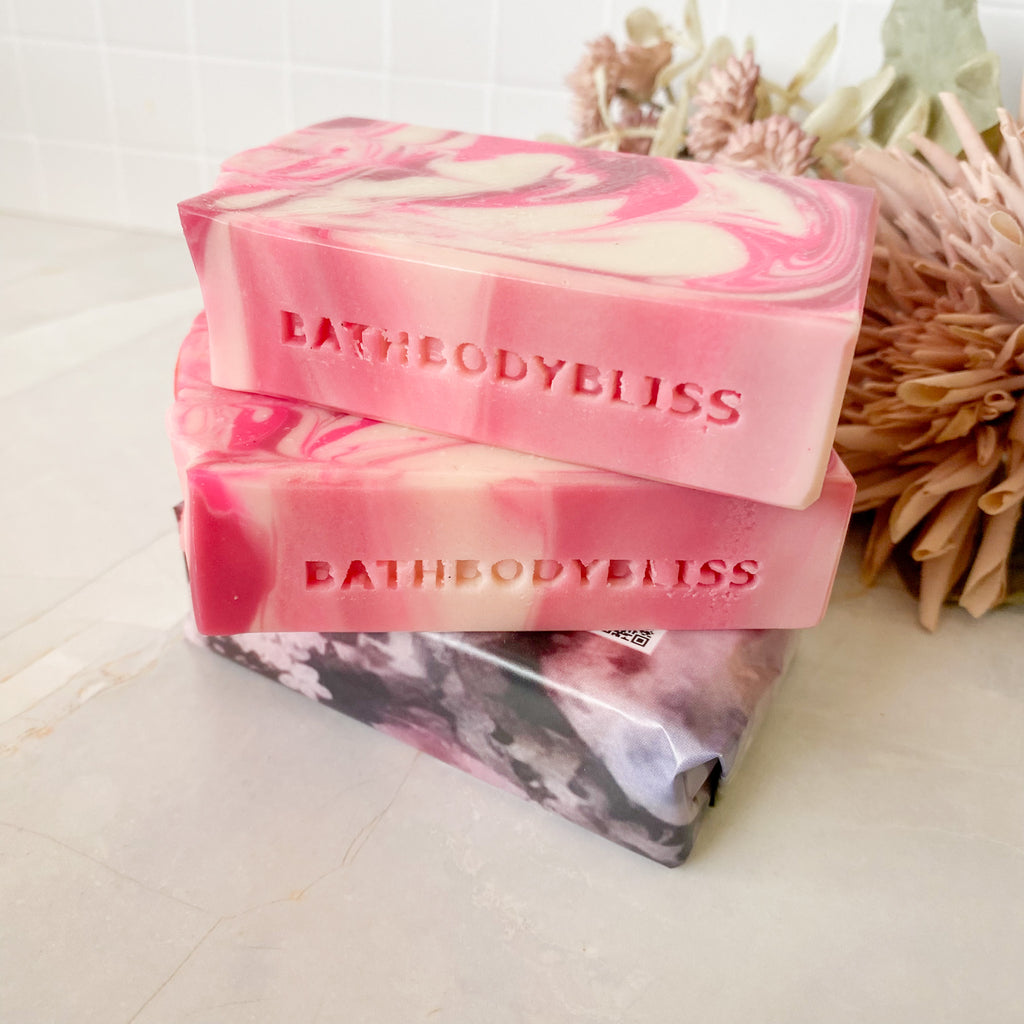 stack of three pink and white swirled soap bars with BATHBODYBLISS impression on the side