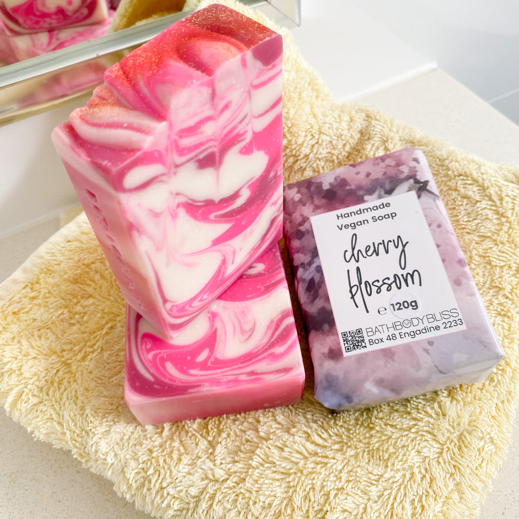 pink and white swirled soap bars stacked on a yellow towel