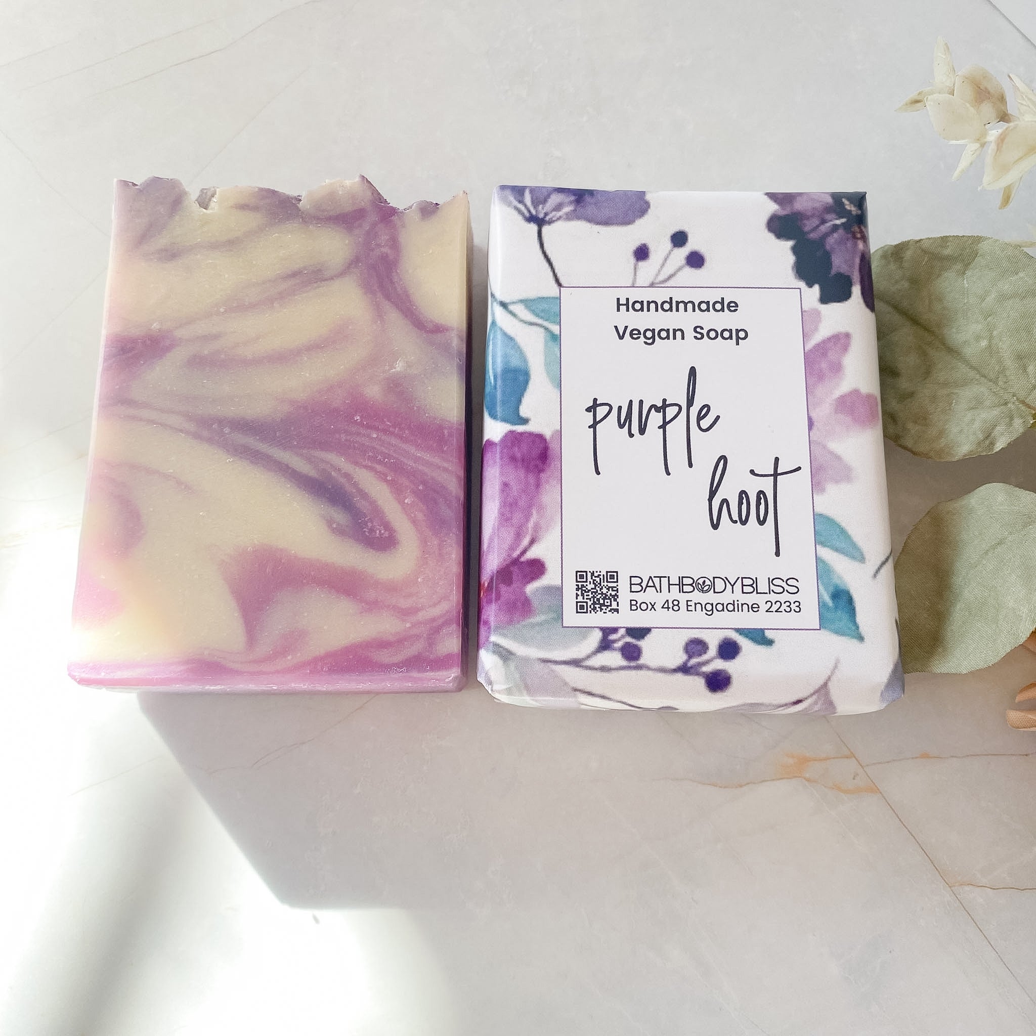 Handmade vegan soap with a purple and white design on a light background