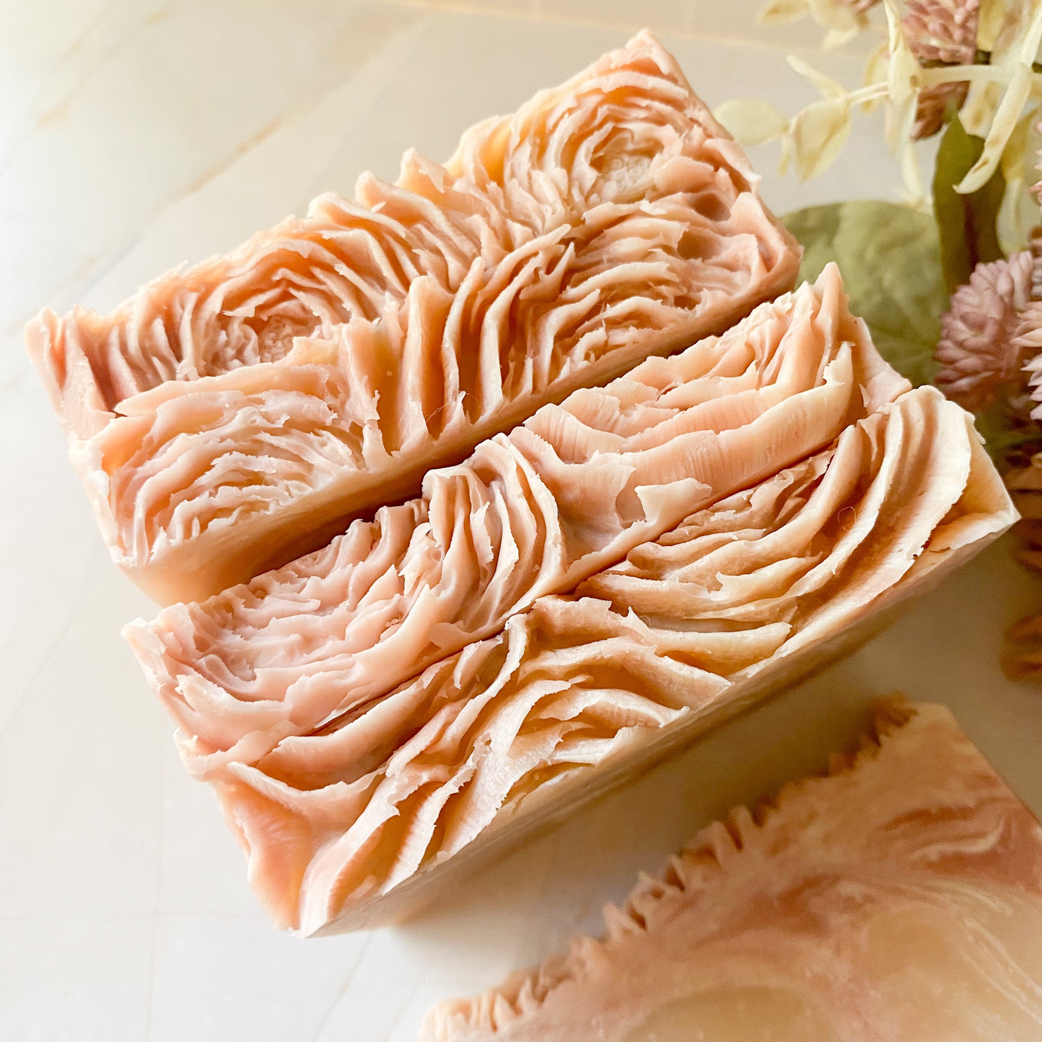 Four bars of decorative soap with a wavy pattern on a light background