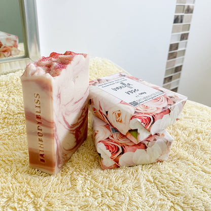 Three bars of soap with floral packaging on a yellow handtowel.
