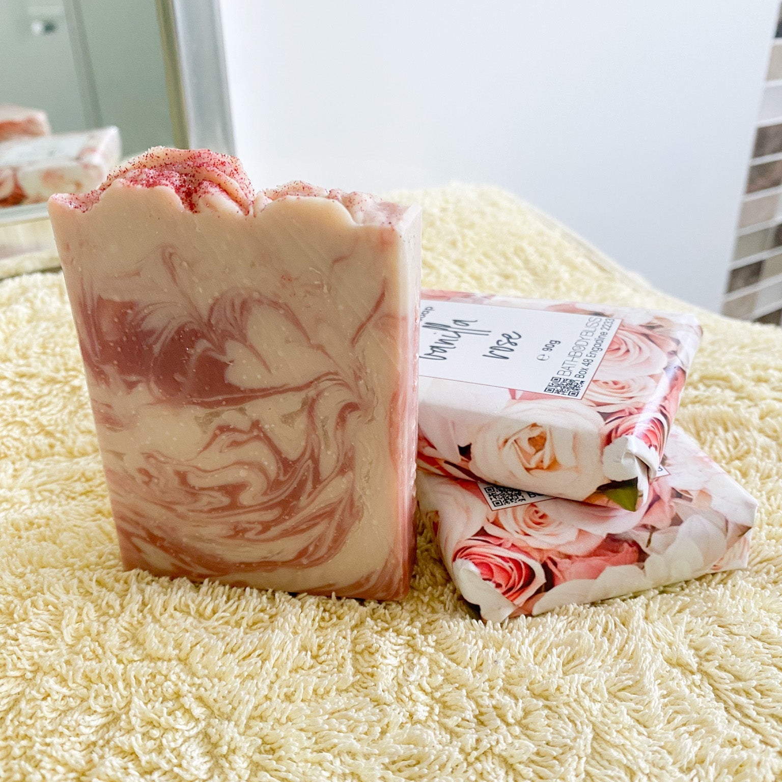 Bar of soap with marbled design and packaging on a textured surface