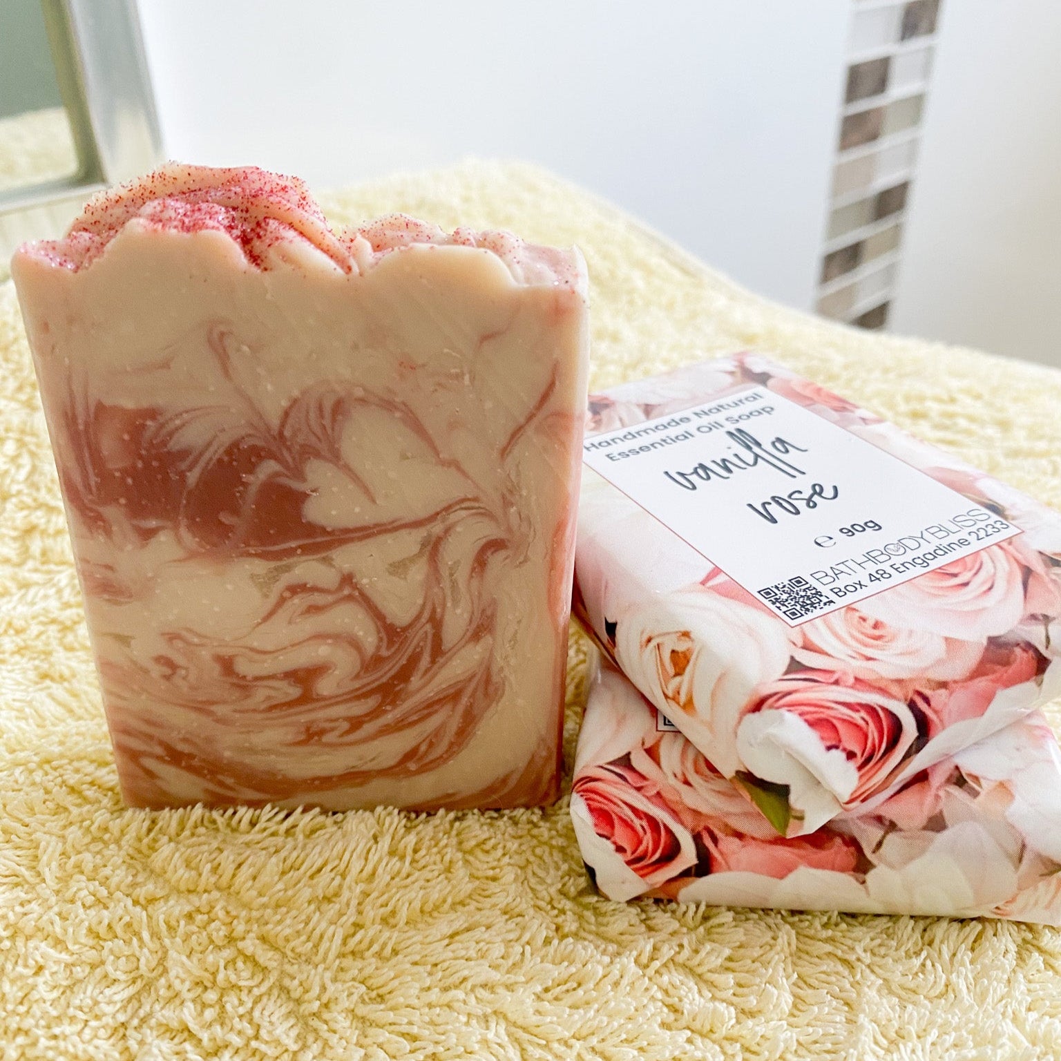 Bar of soap with a floral design and packaging on a textured surface