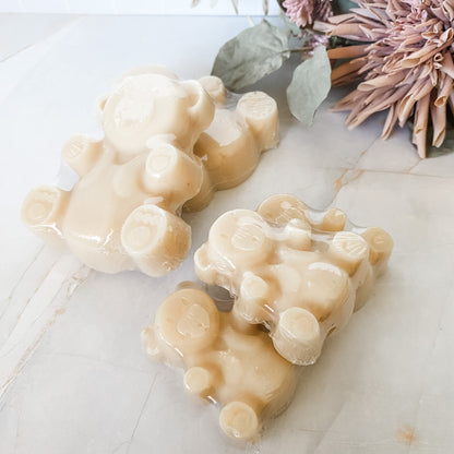 large and small bear-shaped soap bars on a marble surface with decorative elements.