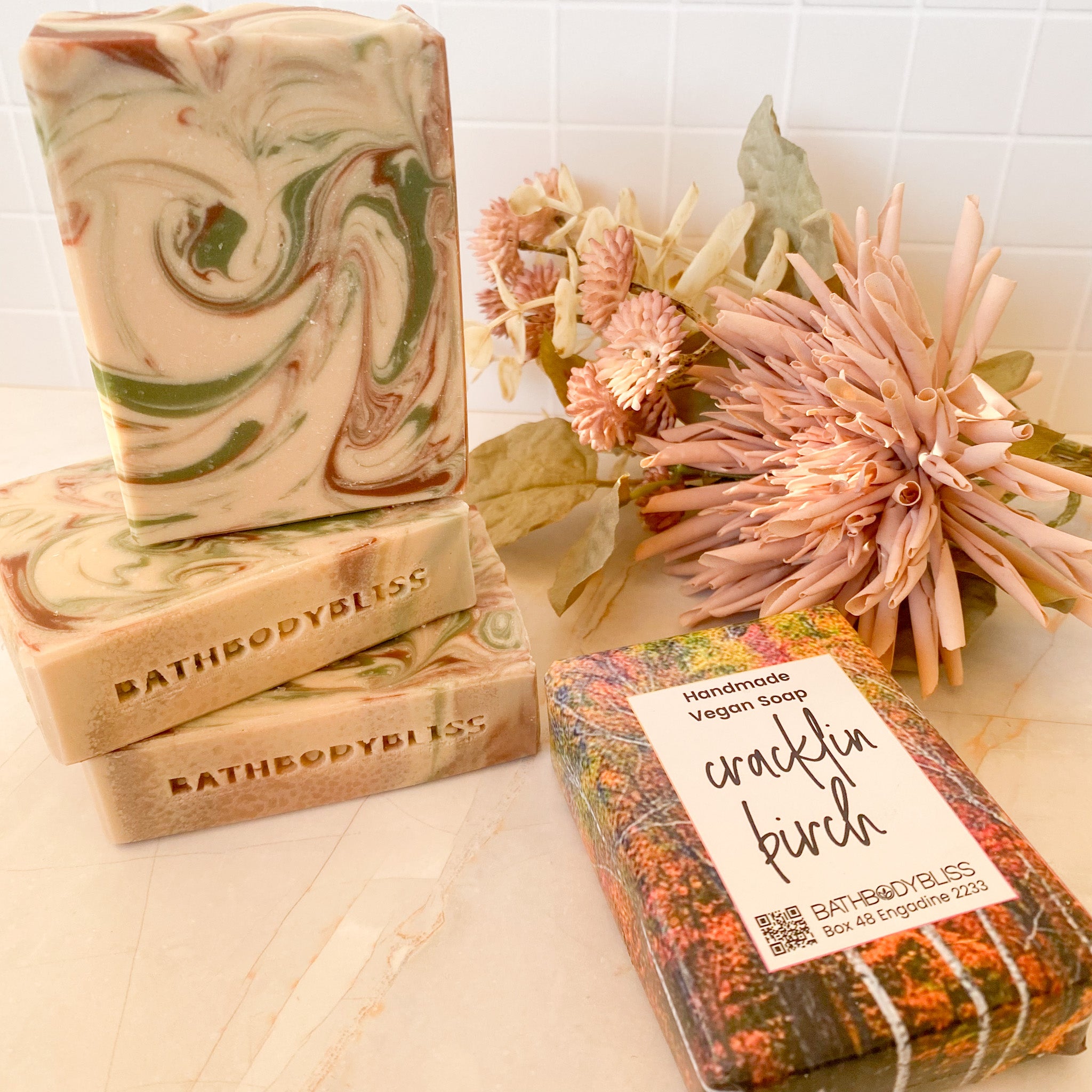 swirled soap bars and wrapped soap bar on a light surface with floral decor