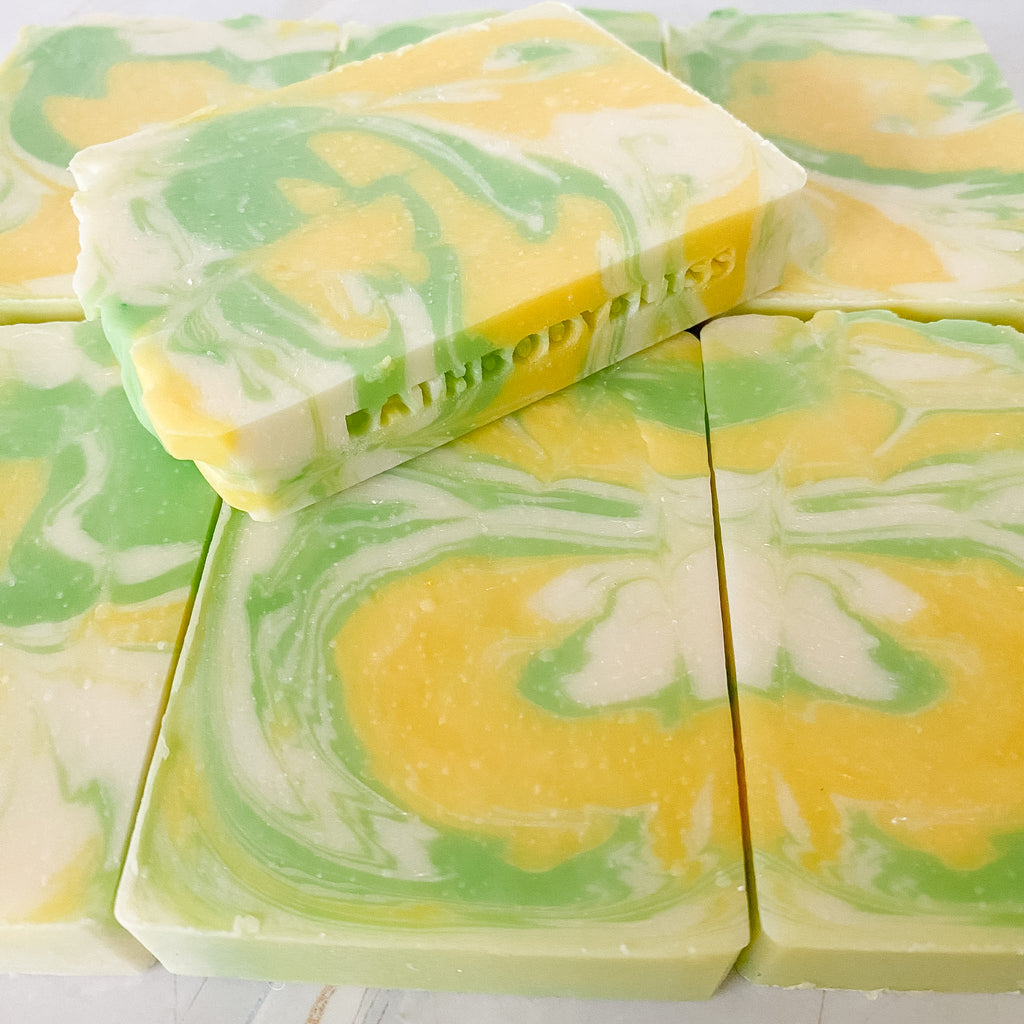 Swirled yellow and green soap bars on a white background