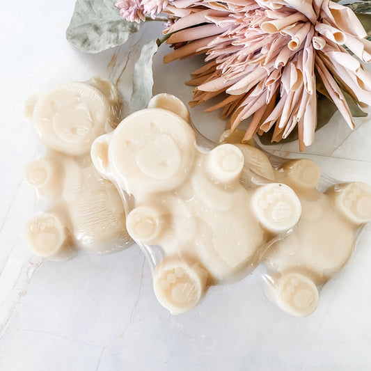 three teddy Bear shaped soaps on a white surface with decorative elements