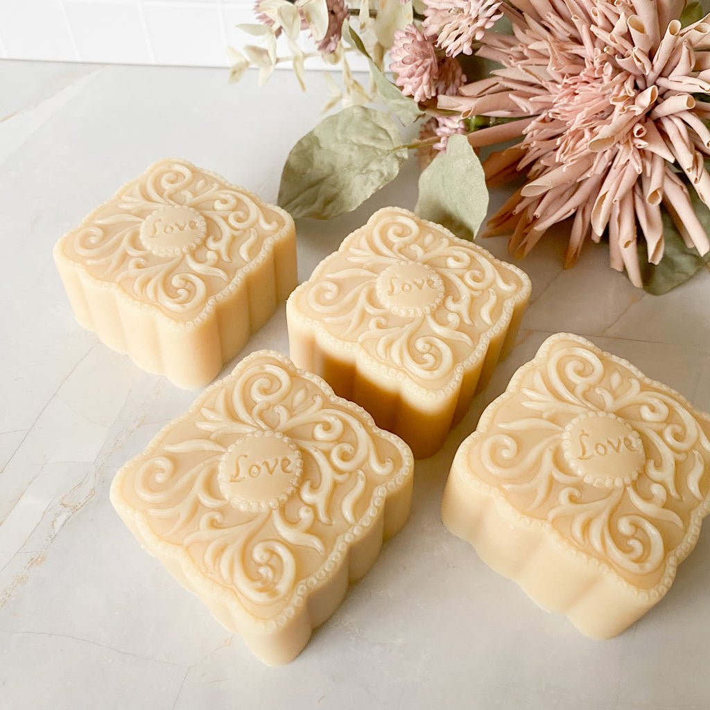 Decorative soap bars with floral arrangement on a light surface