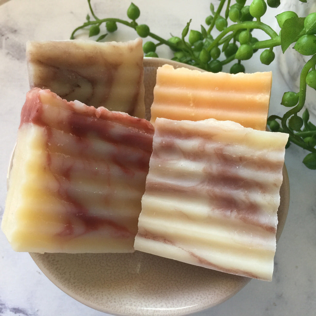 four rippled guest soap bars in a tray with greenery decor