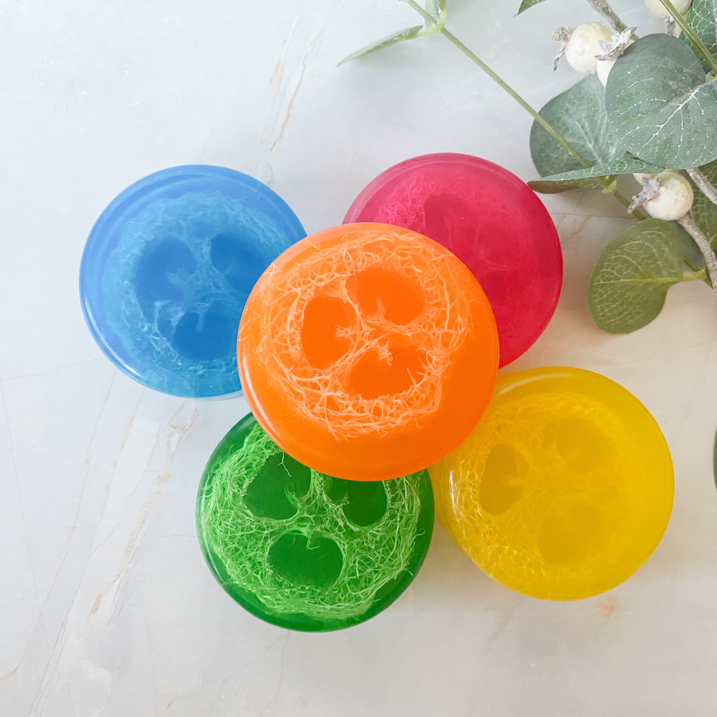 five round colourful soaps with natural loofah embedded inside