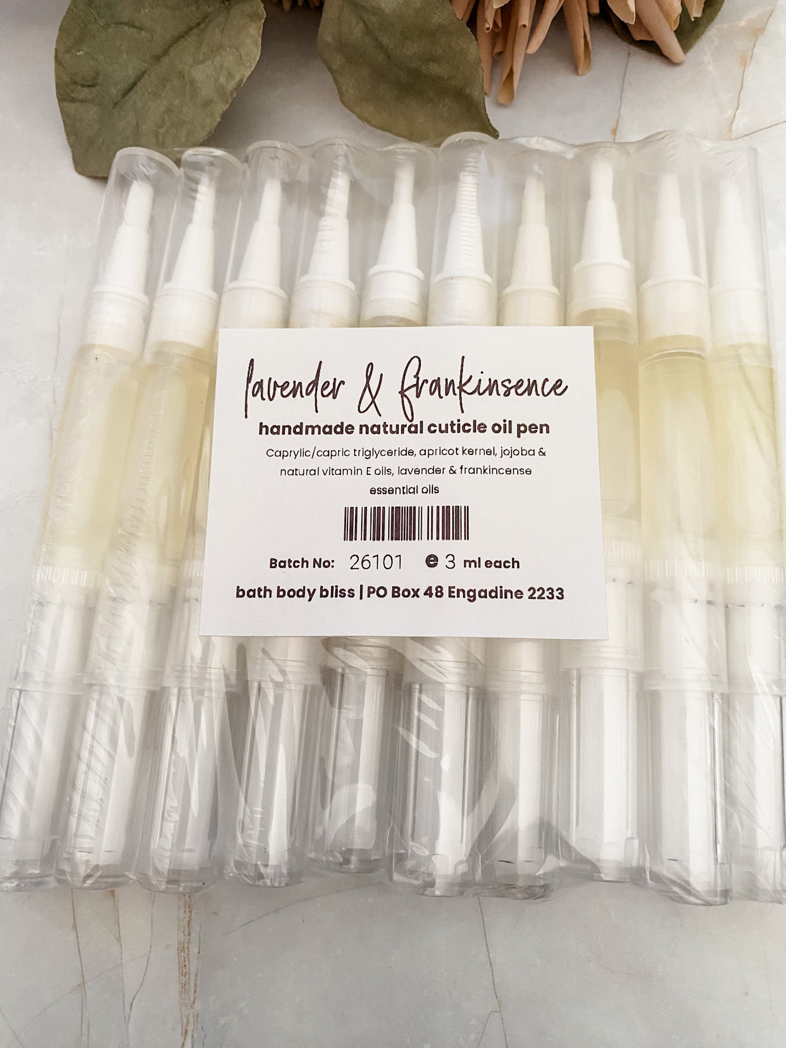 Packaged cuticle oil pens with a label on a light background