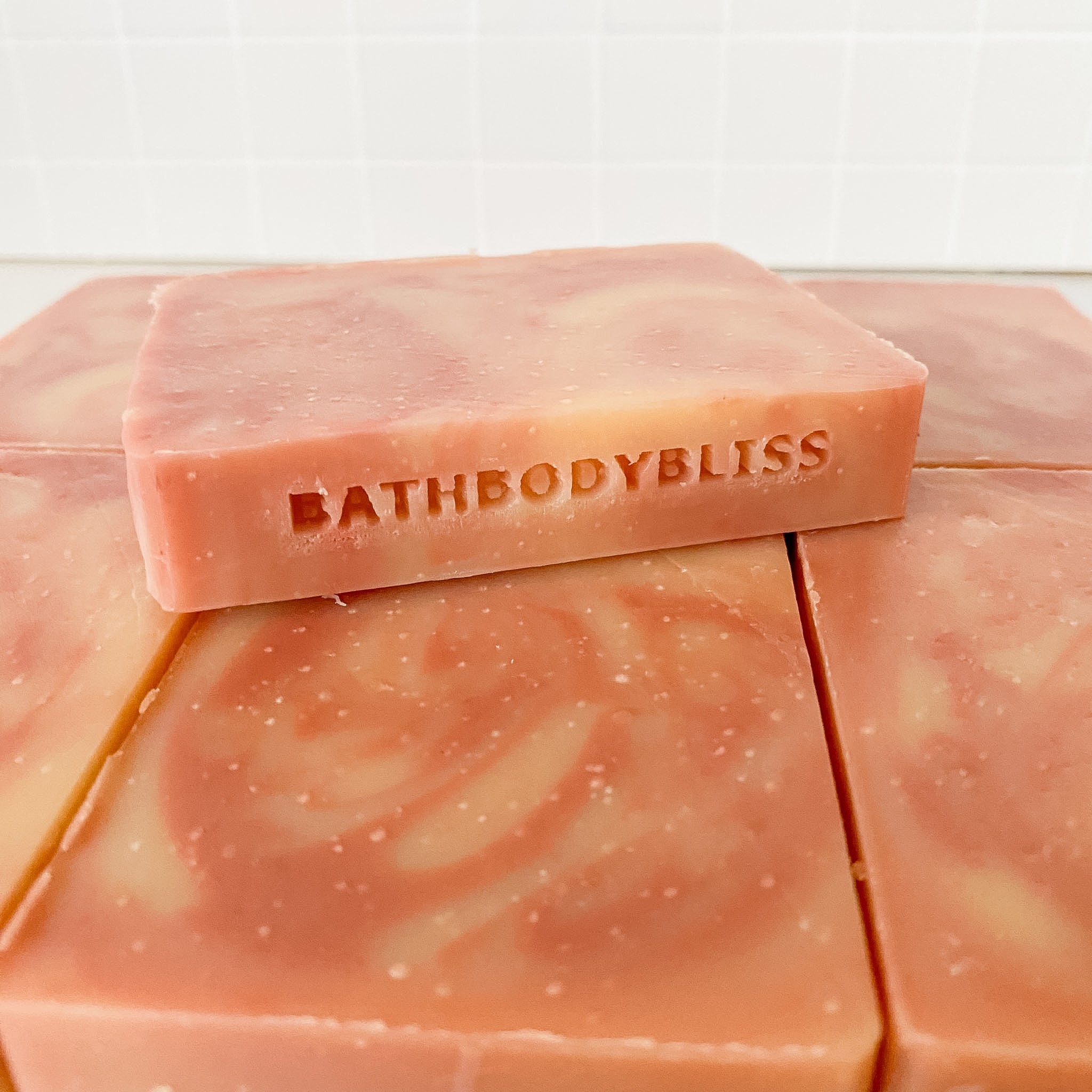 Pink soap bars with 'BathBodyBliss' branding on a white background