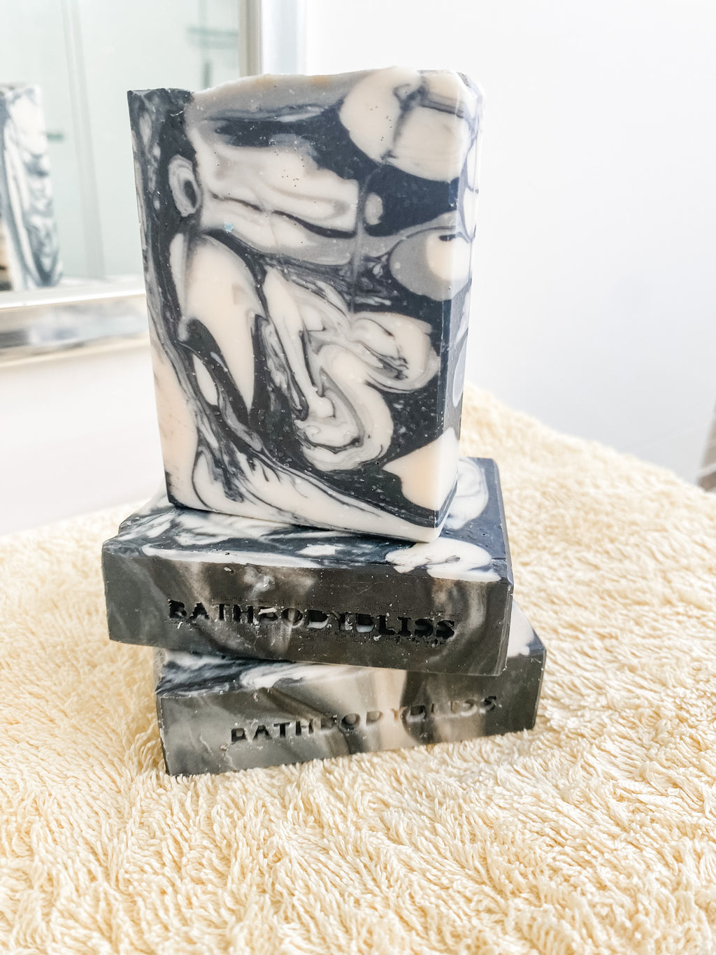 black and white marble pattern handmade soap bars on a yellow towel