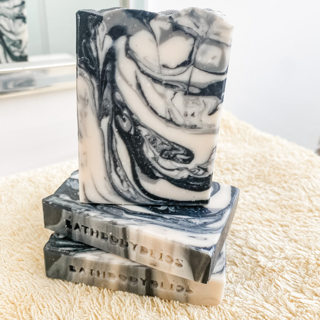 black and white marbled soap bars stacked on a yellow towel