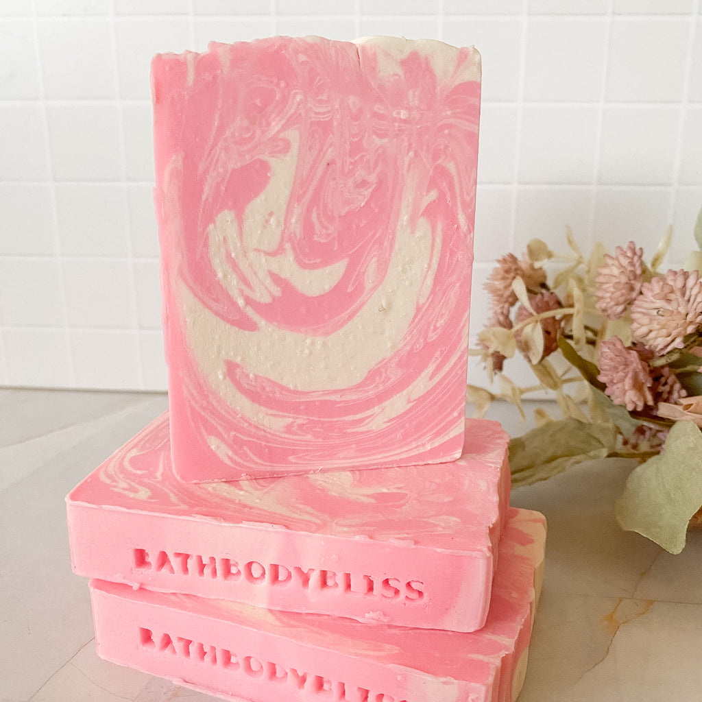 Pink and white swirled soap with 'BathBodyBliss' branding on a light background.