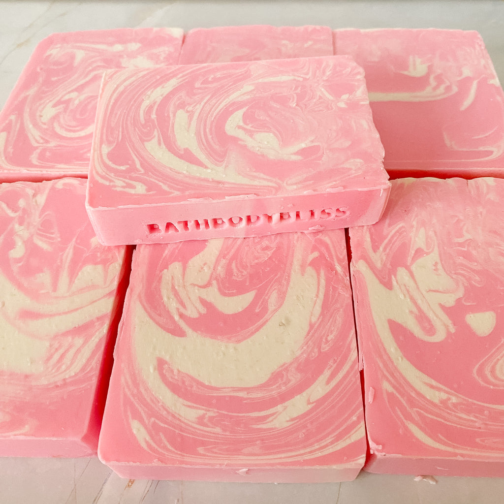 Pink and white swirled soap bars with 'Bath & Body Bliss' branding on a light background.