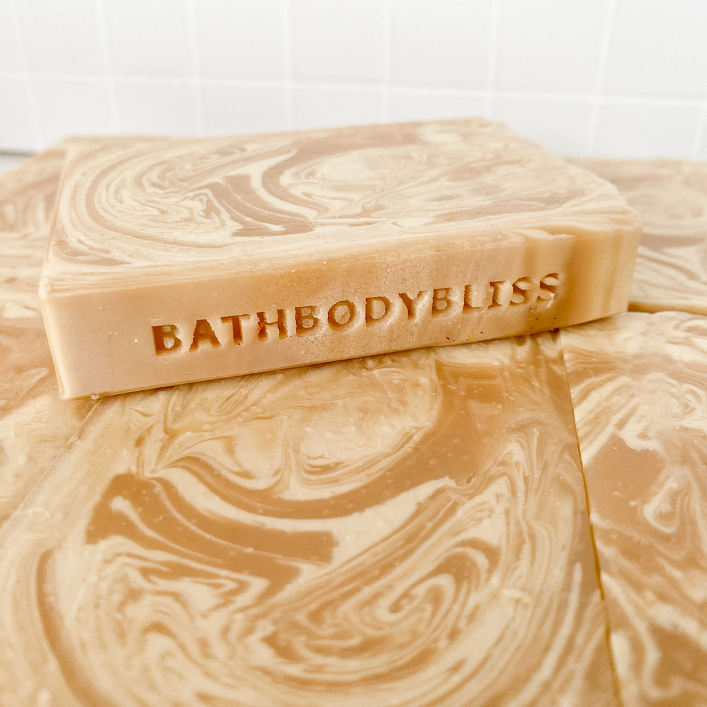 Bars of soap with 'BathBodyBliss' branding on a marble surface
