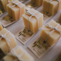 Cubes of handmade favour soaps, tied with twine & attached to a printed thank you card