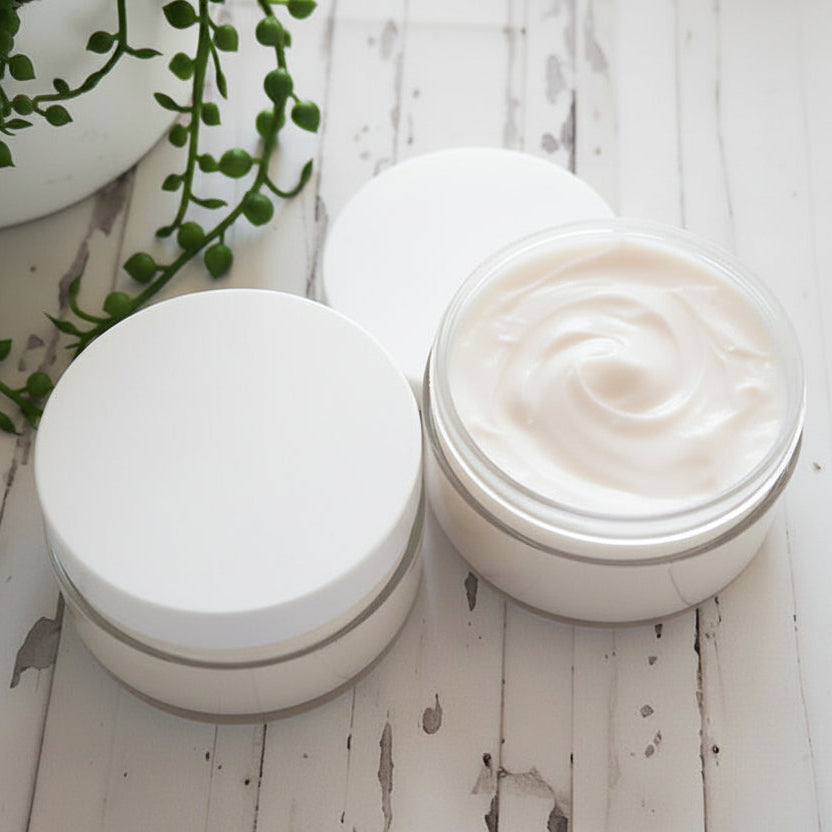 Two jars of cream on a wooden surface with a plant in the background